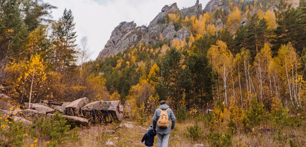 man-and-baby-walking-near-trees-3077837