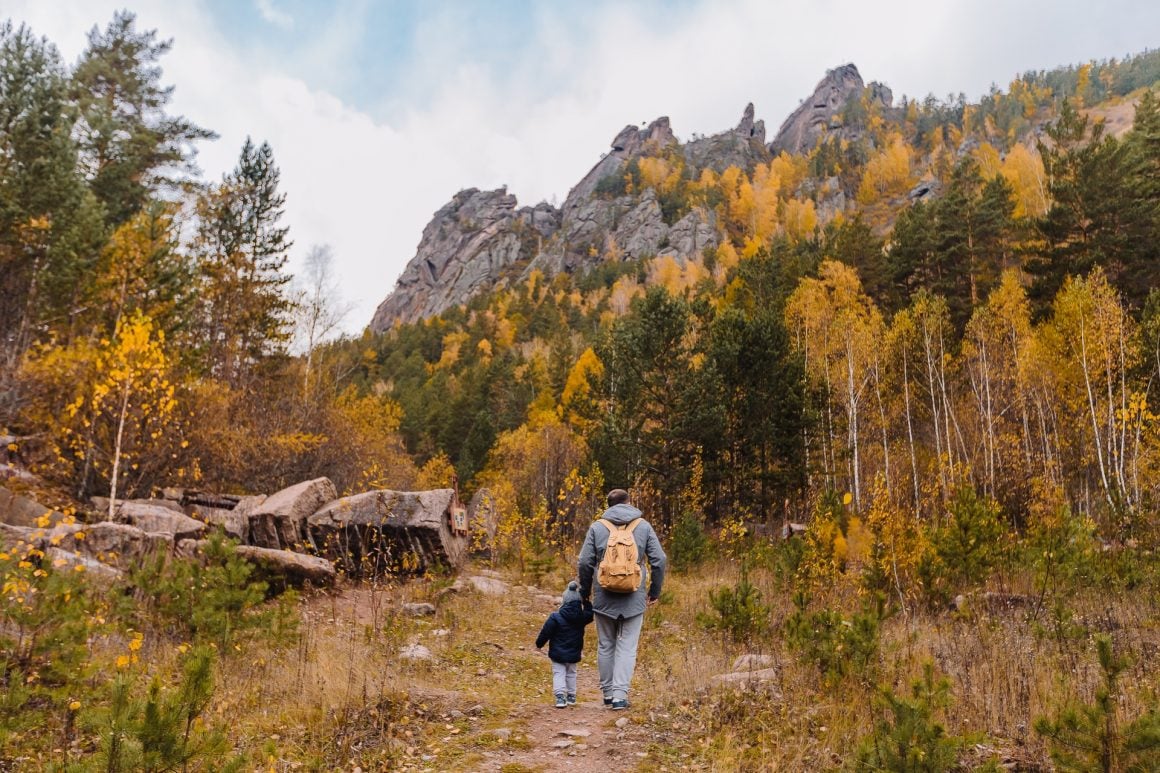 man-and-baby-walking-near-trees-3077837